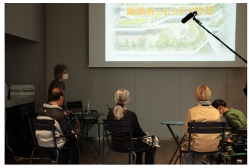 まちづくりプラザで竹芝新八景の説明を聞く体験者の方と説明をする担当者