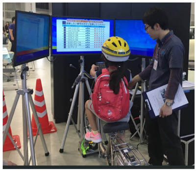 自転車シミュレータで体験している様子の写真